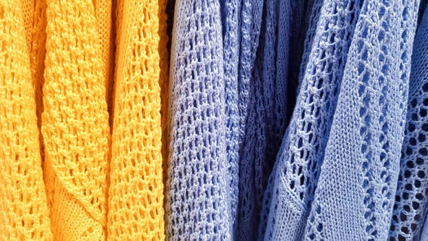 Colors of rainbow. Variety of casual shirts, t-shirts on hangers in a store. Cloth cotton of various bright colors close-up. Textile background.