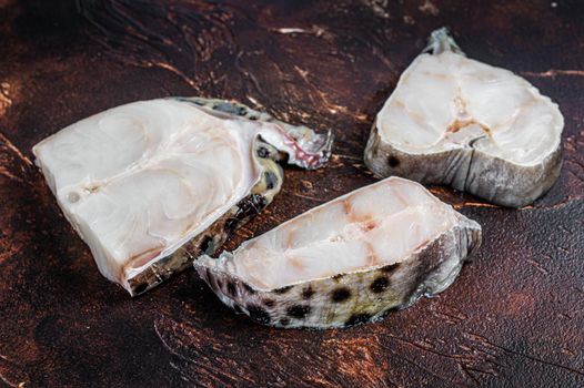 Raw atlantic wolffish fish Steak. Dark background. Top view.