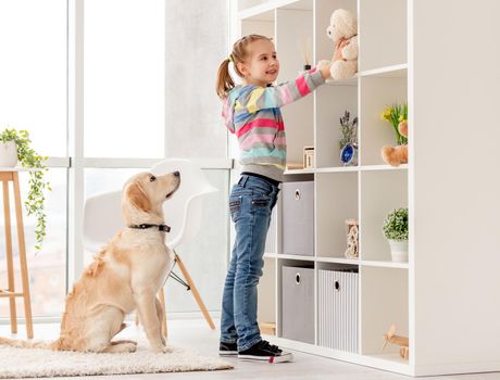 Happy girl with teddy bear and devoted dog indoors