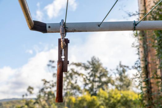 A metal counter weight hanging from a clothes line to stop it from blowing in the wind