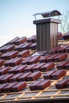 Red tile packs on the roof ready to tile the roof. Technology Weather protection.