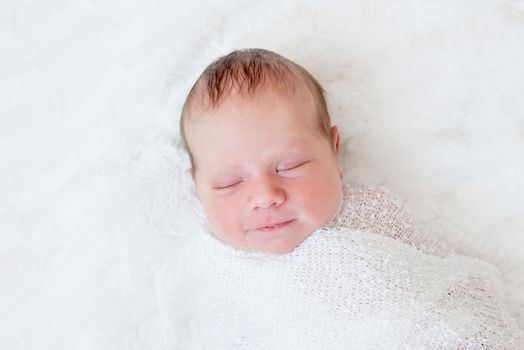 Close-up portrait of sleeping newborn baby. Swaddled newborn baby sleeping