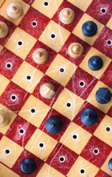Small wooden chess on a chessboard during a game of chess is designed for travel