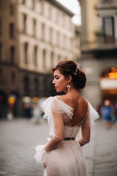 girl-bride wedding dress with a beautiful floral pattern in Florence, stylish bride in a wedding dress stands in the Old city of Italy. Model girl in Florence.