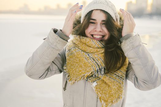 Beautiful happy laughing young woman wearing winter hat and scarf. winter background with snow. Winter holidays concept. Happy Woman In Winter Nature.