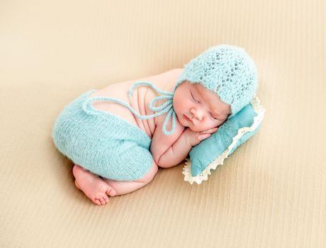 newborn baby girl sleeping sweetly on a little pillow