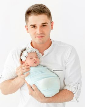 beautiful portrait of a young dad with his newborn daughter on white background