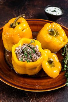 Baked Sweet bell pepper stuffed with beef meat, rice and vegetables. Dark background. Top view.