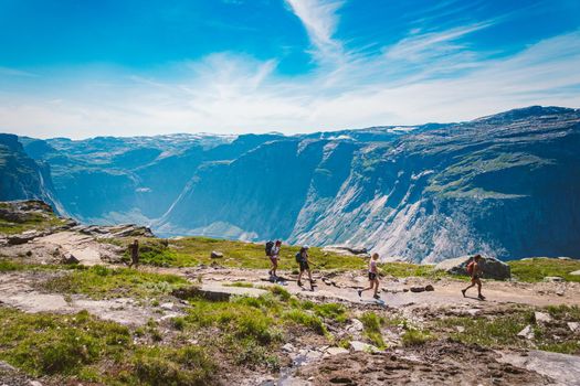 July 26, 2019. Norway tourist route on the trolltunga. People tourists go hiking in the mountains of Norway in fine sunny weather to thetrolltunga. Hiking backpack theme.