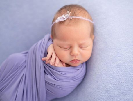 Adorable newborn baby sleeping wrapped up