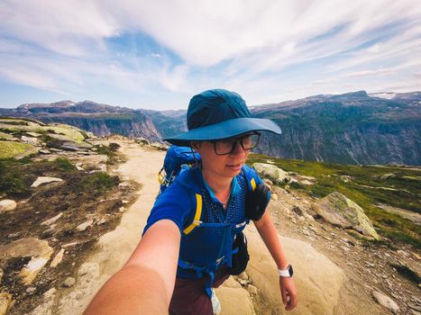 Handsome adventurous human taking selfie mountain. Woman traveler photo yourself action camera in nature. Travel Lifestyle adventure concept active vacations outdoor, hiking success and healthy life.