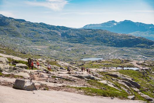 July 26, 2019. Norway tourist route on the trolltunga. People tourists go hiking in the mountains of Norway in fine sunny weather to thetrolltunga. Hiking backpack theme.