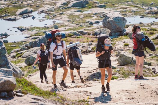 July 26, 2019. Norway tourist route on the trolltunga. People tourists go hiking in the mountains of Norway in fine sunny weather to thetrolltunga. Hiking backpack theme.