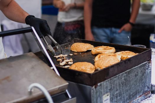 People cooking food on the streets with minimum protection. Take away meal concept, express food service.