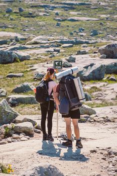 July 26, 2019. Norway tourist route on the trolltunga. People tourists go hiking in the mountains of Norway in fine sunny weather to thetrolltunga. Hiking backpack theme.