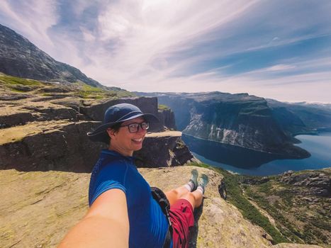 Traveling Lifestyle adventure vacations in Norway aerial view landscape. Hike In Norway. Amazing nature view on the way to Trolltunga. Traveller Standing On Famous Norwegian Natural Sight Trolltunga.