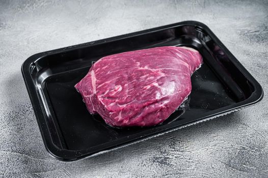 Raw cap rump steak or top sirloin beef meat steak in vacuum packaging. White background. Top view.