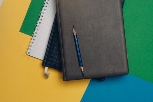 black notepad pencil colorful background office supplies. High quality photo