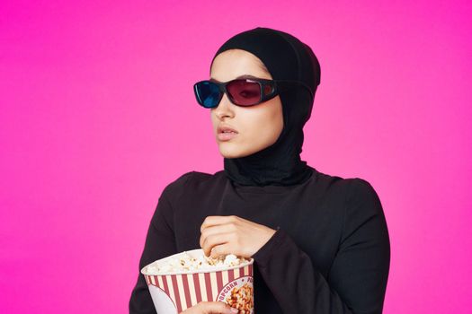 Muslim woman in 3D glasses popcorn entertainment movies model ethnicity. High quality photo
