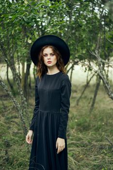 woman in black suit Witch in a fantasy forest. High quality photo