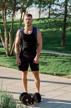 man with dumbbells in the park exercise fitness. High quality photo