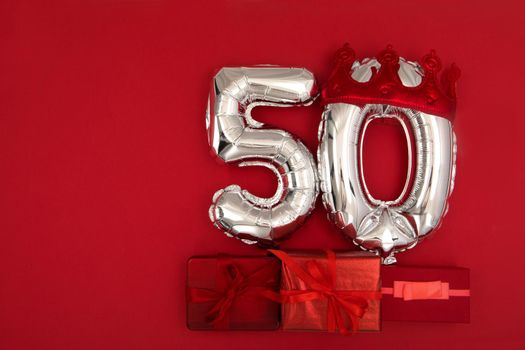 Silver Number Balloons 50 thirty in crown on dark red background. Holiday Party Decoration, 50 postcard concept with top view