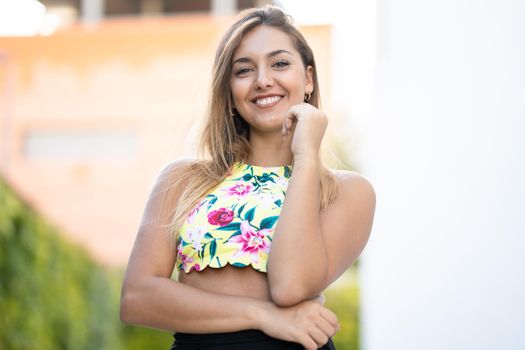 Happy young girl with beautiful straight hair standing outdoors