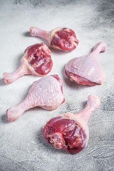 Raw Duck legs drumsticks on butcher table. White background. Top view.