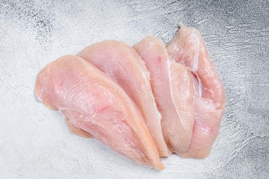 Raw sliced chicken breast fillet steaks. White background. Top view.