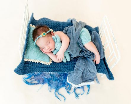 cute newborn baby girl sleeping in a little bed