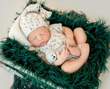 Dreamy newborn baby sleeping peacefully on the side on bed