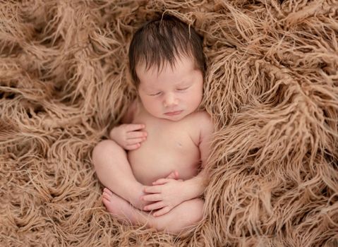 Charming naked newborn calmly sleeping