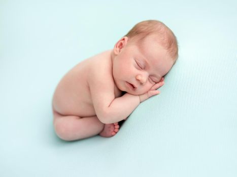 Adorable naked newborn sleeping on stomach