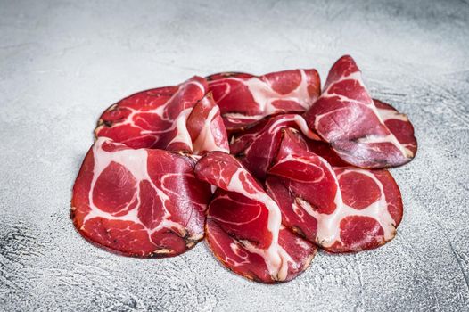 Coppa Cured ham on kitchen table. White background. Top view.