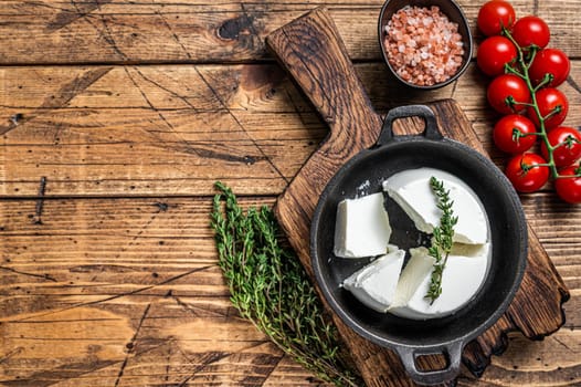 Fresh Ricotta cream Cheese in a pan with basil and tomato. wooden background. Top view. Copy space.