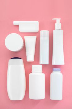 White different types tubes for cosmetics on pink background flatley