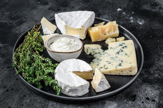 French Cheese plate. Camembert, Brie, Gorgonzola and blue cream cheese. Black background. Top view.