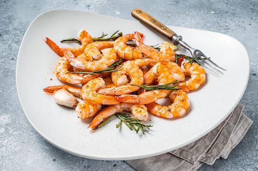 Fried Prawns Shrimps in a plate with herb and garlic. Gray background. Top view.