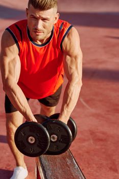 Muscled Man With Dumbbells Outdoor Workout. High quality photo