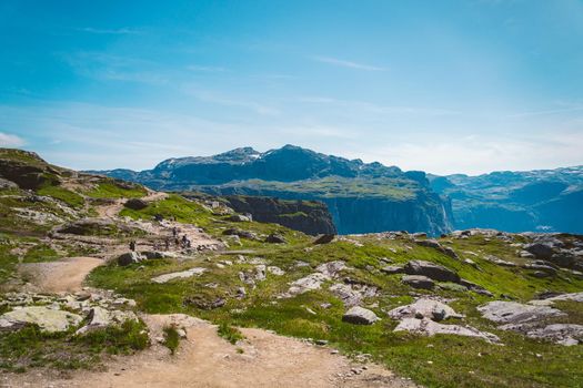 July 26, 2019. Norway tourist route on the trolltunga. People tourists go hiking in the mountains of Norway in fine sunny weather to thetrolltunga. Hiking backpack theme.