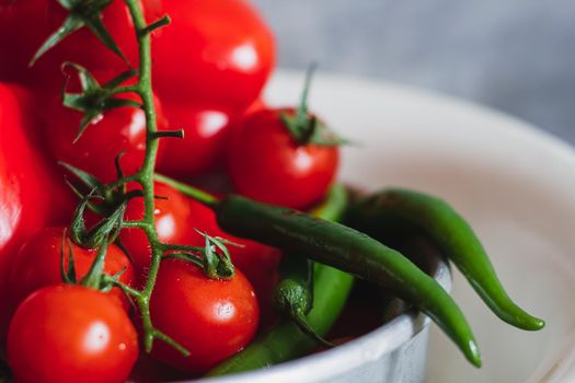 Juicy bright mature cherry tomato close-up large long peppers hot chili pepper green red