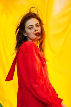 pretty woman in red dress nature yellow cloth on background. High quality photo