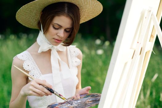 woman artist draws a picture on an easel outdoors. High quality photo