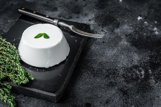 Ricotta cream Cheese on marble board with thyme. Black background. Top view. Copy space.