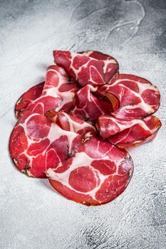 Coppa Cured ham on kitchen table. White background. Top view.