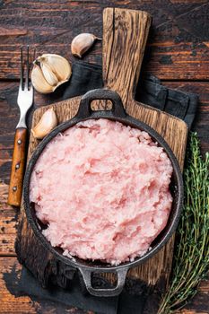 Uncooked Raw minced chicken and turkey meat in a pan with herbs. Dark wooden background. Top view.