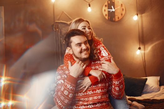 People in a Christman decorations. Man and woman in a red sweater. Family at home.