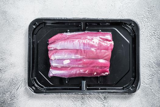 Raw lamb tenderloin in vacuum packaging. White background. Top view.