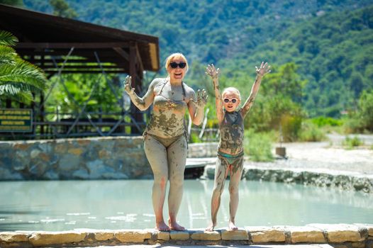 A happy family takes a mud bath at a resort in Turkey.Family wellness in therapeutic mud