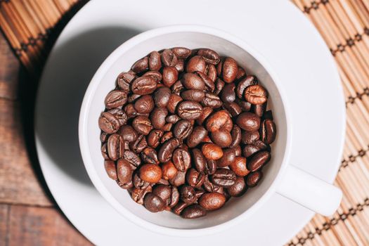 a cup of coffee Hot drink spilled grains wooden table. High quality photo